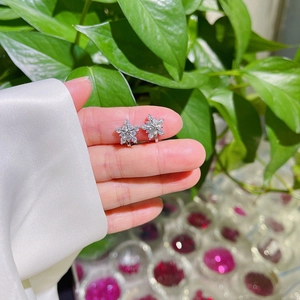 Elegant snowflake stud earrings with AAA zircon stones shown in hand for scale