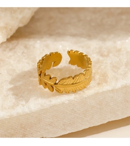 Macro shot of gold leaf feather ring with detailed metal texture on crystal stone