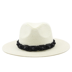 Close-up of cream straw hat with black beaded band and fine woven texture detail