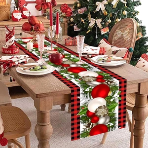 Christmas table runner featuring festive red balls and pine motifs on a wooden dining table