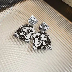 Abstract acrylic earrings featuring black and white female portrait line art on glass surface
