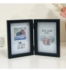 Detail of black double folding photo frame with metal hinges and matte textured finish
