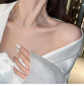 Close-up of sparkling twist titanium steel chain necklace on collarbone with high-shine finish