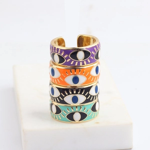Detailed macro of four-piece colorful enamel evil eye rings in adjustable gold alloy finish