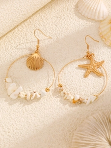 Detalle de pendientes de aro dorados con estrella de mar, concha y piedras naturales