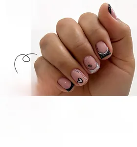 Detail of French press-on nails with black hearts and silver starbursts on pink base