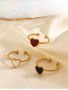 Close-up of three gold-plated heart rings with red white and black enamel on silk