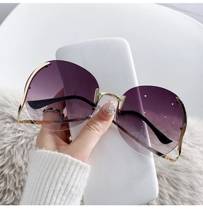 Detailed close-up of rimless sunglasses with purple gradient lenses and gold metal parts