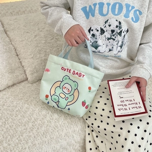 Close-up of cute green canvas tote bag with cartoon print and soft texture details