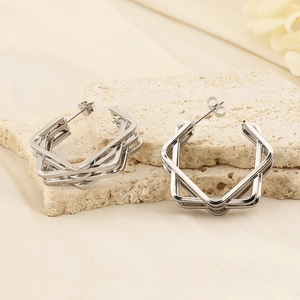 Minimalist silver geometric multilayer hexagonal earrings on beige stone texture
