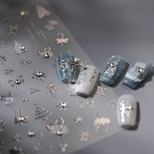 3D silver Christmas nail stickers featuring snowflakes and trees on blue nail art