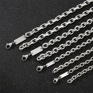 Macro view of silver stainless steel curb chains with lobster clasps and blank rectangular tags