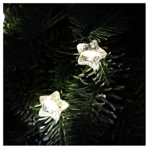 Macro detail of warm white star-shaped LED fairy lights on dark green pine branches