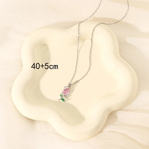 Detailed view of tulip pendant with pink zircon and silver chain in a jewelry dish