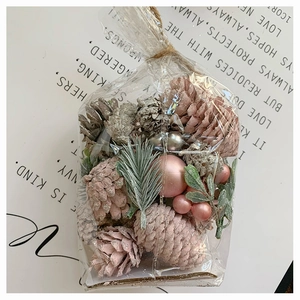 Close-up of pink pine cones and frosted berries in a rustic gift bag with twine bow