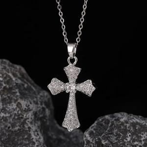 Dettaglio macro del ciondolo a croce in argento con zirconi a micro-pave su catena fine