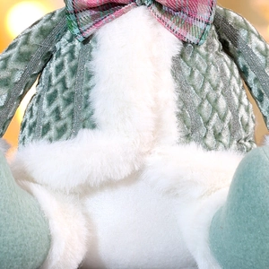 Detail der grünen Strickware und weißem Kunstfell an der Weihnachts-Plüschpuppe