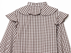Détail du col à volants et du motif vichy marron au dos de la chemise en coton