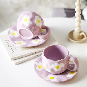 Detailed view of handmade purple ceramic cup and saucer set with floral pattern motifs