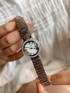 Detail of silver women watch with diamond bezel and blue sapphire crown on wrist