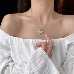 Gros plan du collier nœud en zircon rose et de la bague assortie portés par un mannequin