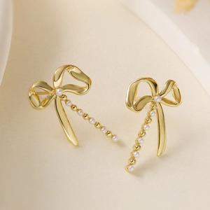 Exquisite gold plated bow earrings featuring white pearls and zircon accents for women