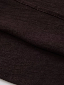 Vista macro de la tela marrón café que muestra la textura tejida y fibras del vestido