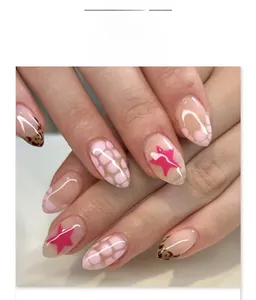 Faux ongles amande courts avec motifs d'étoiles rouges, pointes léopard et pois roses