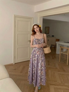 Gros plan détaillé d'une robe maxi à fleurs mauves avec fines bretelles et décolleté en V