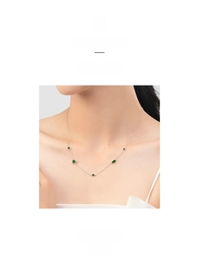 Macro view of dainty S925 silver necklace featuring five vibrant emerald green zircons