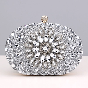 Close-up of sparkling silver rhinestone evening clutch with flower pattern and ball clasp