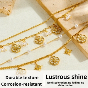 Detailed macro view of gold plated multi-layer chain bracelet with pearls and flower charms