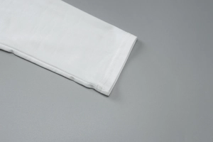 Détail du poignet d'une robe en coton blanc avec des coutures nettes et une texture fine