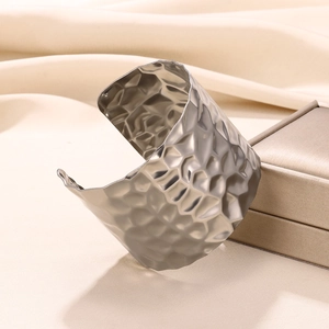 Macro detail of hammered texture on wide stainless steel cuff bracelet for women