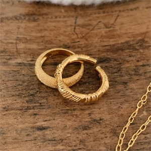 Macro shot of gold-plated twisted and matte hoop earrings with S925 hallmark engraving