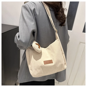 Detail of beige corduroy tote bag with brown FASHION label and small matching purse