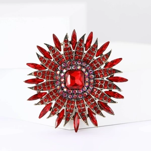 Luxurious sunflower alloy brooch with red rhinestones and gemstones on white stand