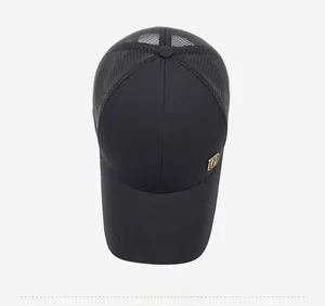 Detailed top view of a black trucker hat with mesh panels and a square gold metal plaque