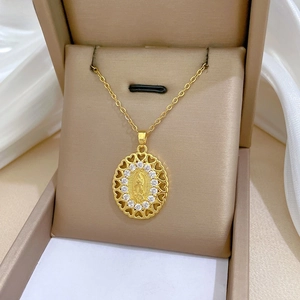 Macro view of gold titanium steel necklace with oval Virgin Mary relief and zircons