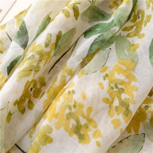 Detailed macro view of yellow leaf print on breathable cotton linen scarf fabric