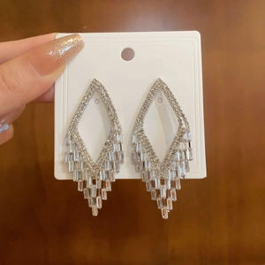 Detailed view of silver tassel earrings with sparkling rhinestones in a long drop design