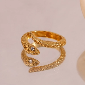 Close-up of gold-plated snake ring with sparkling white diamond eyes and scale texture