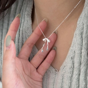 Elegant 925 sterling silver bow necklace shown on neck with a minimalist style