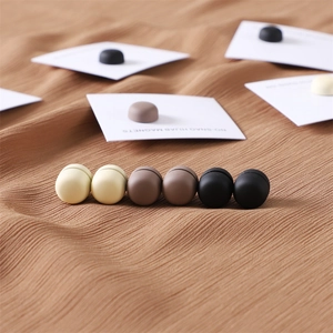 Neutral matte hijab magnets in beige, coffee, and black on a soft textured fabric background