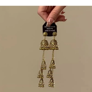 Detailed close-up of retro gold multi-layer Jhumka earrings with ethnic bell tassels