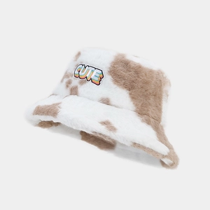 Gros plan sur l'étiquette CUTE arc-en-ciel d'un bob en peluche avec motif de vache