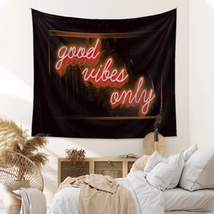 Detail of neon good vibes only text on a black bohemian fabric wall tapestry
