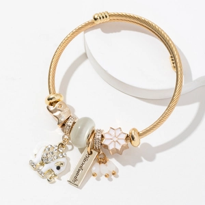 Detailed macro of gold elephant charm with crystals and flower bead on cable bracelet