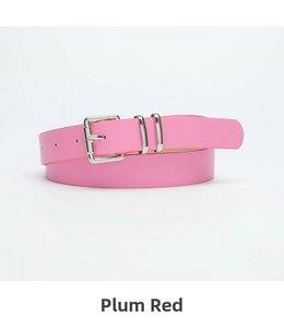 Close-up of rose red leather belt with silver pin buckle and dual metallic loops