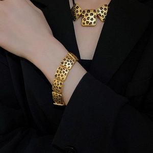 Detailansicht von Vintage-Goldkette und Armband mit Leopardenmuster und orangen Strasssteinen